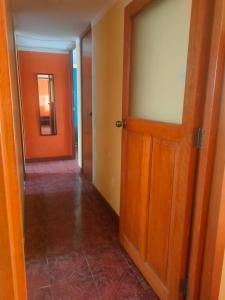 an empty hallway with an open wooden door at MUNAYCHA`S WASI in Cusco