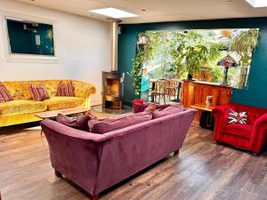 ソルカムにあるBrightham Houseのリビングルーム(紫色のソファ、赤い椅子付)