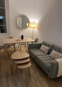 sala de estar con sofá, mesa y espejo en Charmant 3 pièces à Nice en Niza