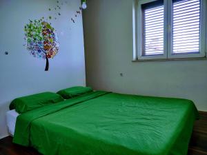 a bedroom with a bed with a green comforter at Viridis in Rijeka