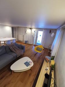 a living room with a couch and a surfboard at L'Orée, appartement cosy, 4 à 6 pers in Villard-de-Lans