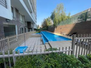 a swimming pool in front of a building at Apartamento/Estudio en Las Condes in Santiago
