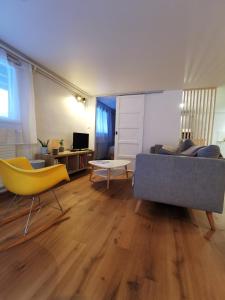 a living room with a couch and a yellow chair at L'Orée, appartement cosy, 4 à 6 pers in Villard-de-Lans