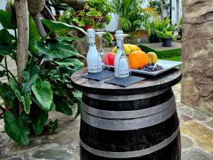 due bottiglie sopra un barile con un piatto di frutta di Suite 85, Villa Boutique privada con piscina a Icod de los Vinos