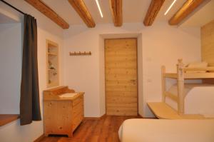 a bedroom with a bunk bed and a wooden door at Cèsa Sès da mont in Livinallongo del Col di Lana