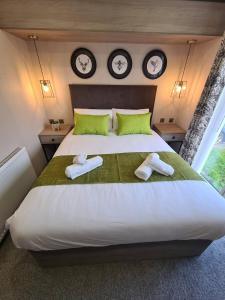a bedroom with a large bed with two towels on it at Heather William Luxury Lodge in Woodhall Spa in Woodhall Spa