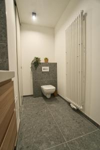a bathroom with a toilet with a plant on the wall at Goethe-Suites: Premium 4 Person Worms city centre Appartment in Worms