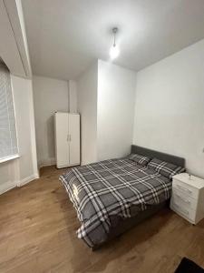 a bedroom with a bed and a cabinet in it at Leicester spacious flat with free parking in Leicester