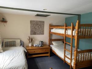 a room with two bunk beds and a table at Loch Ness Backpackers Lodge in Drumnadrochit