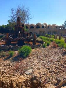 a building with a pile of rocks in a yard at Oasis Panorama Hotel in Bawati