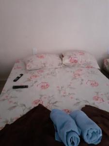 Cama con sábanas y almohadas rosas y blancas en Espaço igor, en Aparecida