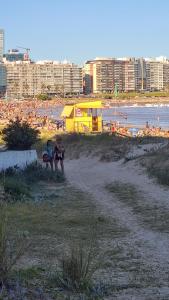 a couple of people sitting on a beach at Montevideo Port Hostel in Montevideo