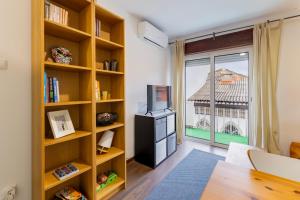 a living room with a tv and a large window at Cosy Remodeled apartment in the City center in Fundão