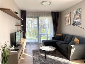 a living room with a couch and a tv at Open Sea Panorama Residence in Obzor