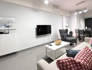 a living room with a couch and chairs and a tv at Prometheus Apt in Piraeus