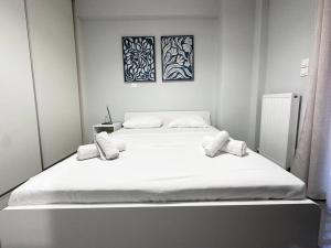 - une chambre avec un grand lit blanc et 2 oreillers dans l'établissement Prometheus Apt, au Pirée