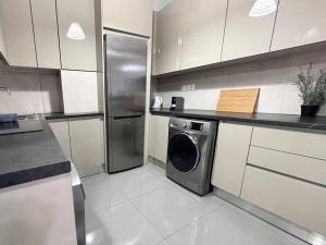 a kitchen with a refrigerator and a washing machine at Prometheus Apt in Piraeus