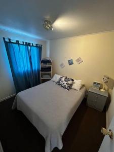 1 dormitorio con 1 cama con cortina azul en CASA EN GUANAQUEROS, en Coquimbo