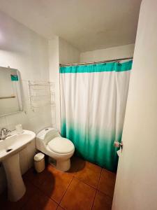 y baño con aseo blanco y lavamanos. en CASA EN GUANAQUEROS, en Coquimbo