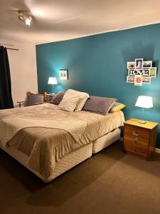 1 dormitorio con 1 cama grande y pared azul en CASA EN GUANAQUEROS, en Coquimbo