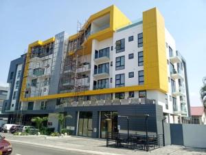 a yellow and white building on the side of a street at Luxurious 2 Bedroom The Edge Labone in Accra