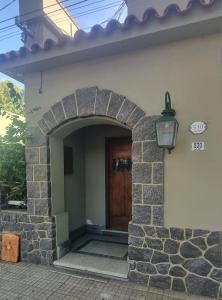 una entrada a una casa con un arco y una puerta en Posada Santa Rita, en Colonia del Sacramento