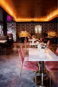 a row of tables with pink chairs in a restaurant at V Palm Springs in Palm Springs