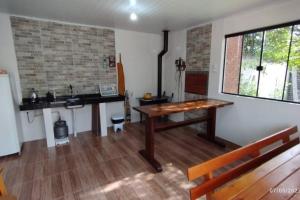 ein Wohnzimmer mit einem Holztisch und einer Bank in der Unterkunft Edícula familiar - Ao lado BR277 in Guarapuava