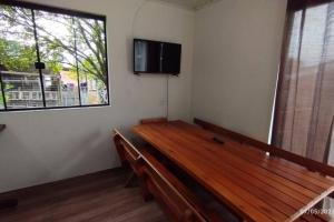 a room with a bench and a tv on a wall at Edícula familiar - Ao lado BR277 in Guarapuava