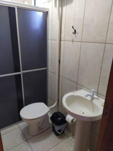 a bathroom with a toilet and a sink and a shower at Edícula familiar - Ao lado BR277 in Guarapuava