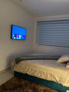 1 dormitorio con 1 cama y TV en la pared en LuxeNew, en Tánger