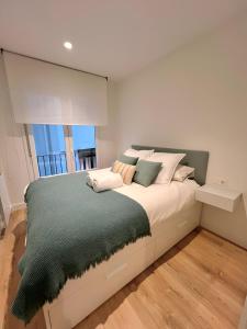 a bedroom with a large bed with a large window at COLON APARTMENT -Zurriola Beach in San Sebastián