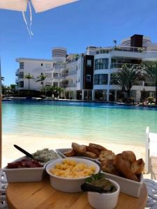 a tray of food on a table next to a pool at Apartamento vista mar resort in Florianópolis
