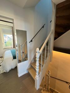 ダンケルクにあるMaison Belle Rade : L’écoutilleの階段、ベッド、窓が備わる客室です。