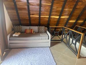 a small bed in a room with a wooden ceiling at Piece Of Heaven Cabins in Palmira