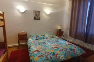 a bedroom with a bed with a colorful comforter at Grand appartement proche Paris in Montreuil