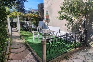 a fence with a table and chairs and an umbrella at Grand appartement proche Paris in Montreuil