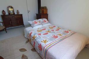 a bedroom with a bed with a colorful comforter at Grand appartement proche Paris in Montreuil