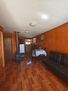 a living room with a couch and a table at Cabaña Queule in El Crucero