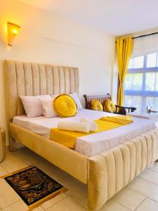 uma cama grande com uma grande cabeceira num quarto em Sophlin home em Ukunda