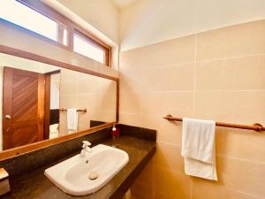 een badkamer met een wastafel en een spiegel bij Sophlin home in Ukunda