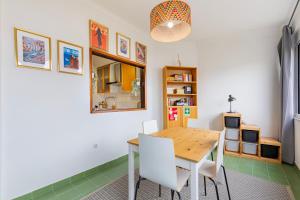a dining room with a wooden table and white chairs at Remodeled historical apartment in the City center in Fundão