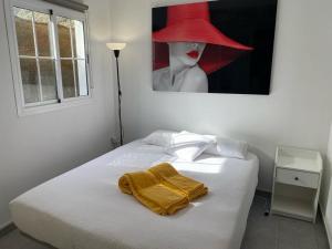 a bedroom with a bed with a red hat on it at SUNNY CARMELITO DELUXE in Mogán