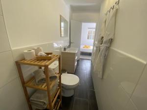 a white bathroom with a toilet and a sink at SUNNY CARMELITO DELUXE in Mogán