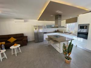 a kitchen and living room with a couch and a table at SUNNY CARMELITO DELUXE in Mogán