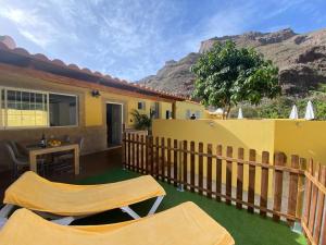 a house with a fence and a table and chairs at SUNNY CARMELITO DELUXE in Mogán