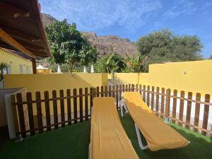 a wooden bench sitting on the side of a fence at SUNNY CARMELITO DELUXE in Mogán