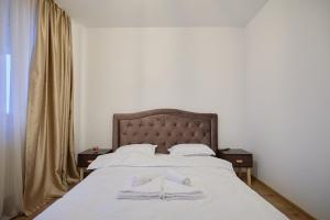 una camera da letto con un letto e due asciugamani di Alessandro Home 11 Luxury Centru Palas Mall Iași Q Residence a Iaşi