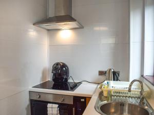 a kitchen with a sink and a helmet on the counter at Largs Sunset in Largs