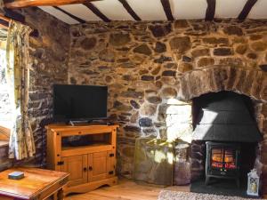 a living room with a stone wall with a fireplace at Middle Kellet - Uk46180 in Silecroft